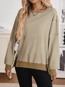 Detail of olive green and white striped sweatshirt showing side slits and ribbed cuffs