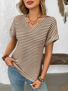 Macro detail of brown and white striped knit top showing the V-neck and textured fabric