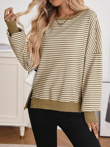 Detail of olive green and beige striped knit sweater with diagonal pattern and ribbed cuffs