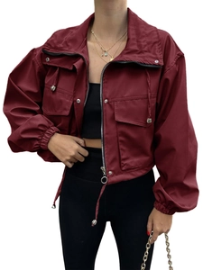 Detail view of burgundy cropped windbreaker jacket with metal zipper and flap pockets