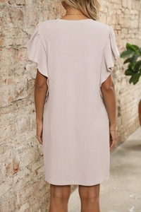 Detail of light pink summer dress with ruffle sleeves and vertical texture on textured fabric