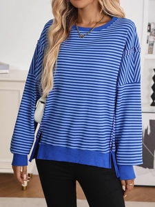 Detail of blue striped knit sweater featuring a ribbed crewneck and side slit design