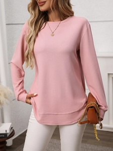 Detailed close-up of pink waffle knit texture and curved overlapping hemline on long sleeve tee