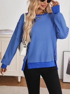 Close-up detail of blue striped knit sweater featuring side slits and rib texture