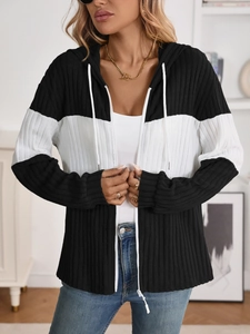 Close-up of contrast color ribbed fabric with zipper and drawstring details on a hoodie