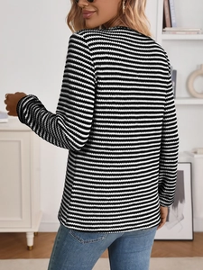 Rear view of a black and white striped long-sleeve knit top with a classic crew neck