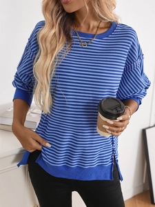 Detail of color-block striped knit sweater featuring side slits and ribbed cuffs