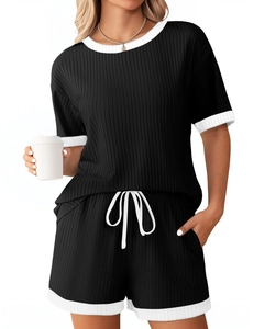 Detail des gerippten Strickstoffs am schwarzen Pyjama-Set mit weißem Saum und Kordelzug