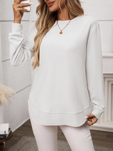 Close-up of white waffle knit texture and ribbed cuffs on casual long-sleeve top