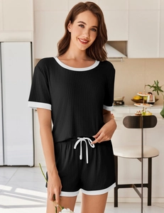 Detail eines schwarzen gerippten Loungewear-Sets mit weißen Kontrastpaspeln und Kordelzug