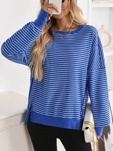Detail of color block blue knit sweater showing crewneck and textured ribbed fabric