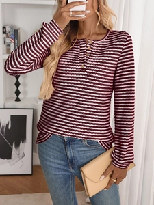 Detail of burgundy striped knit top featuring a buttoned Henley neckline and texture