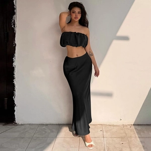 Detail of elegant black off-shoulder ruched top and silky slim fit skirt set on model