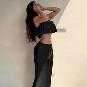 Detail of elegant black satin two-piece set featuring a tube top and long maxi skirt