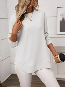 Close-up of light gray waffle knit long sleeve top with curved hem and texture details