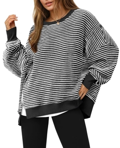 Detailed view of striped knit sweater texture with ribbed cuffs and side slit hem