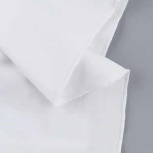 Detail of white V-neck top showing high-density overlock stitching and fabric texture