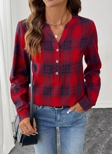 Detail of red and navy plaid women's blouse featuring a V-neckline and metallic buttons
