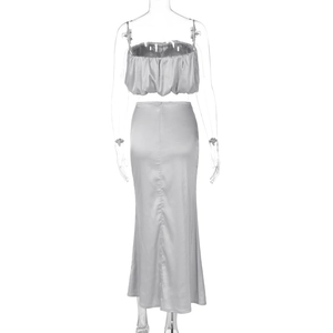 Rear view of silver satin two-piece set featuring off-shoulder top and midi skirt