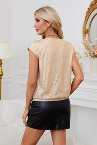 Détail de haut à paillettes dorées avec col en V montrant la texture et la brillance