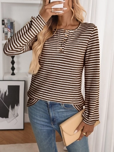 Detail of Henley neck knit top with wooden buttons and brown white striped texture