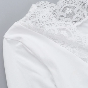 Close-up of elegant V-neckline with delicate floral lace trim on white fabric