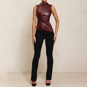 Detail of burgundy ruched faux leather top featuring asymmetrical hem and sleeveless design