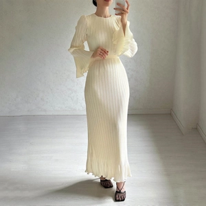 Detailed view of the vertical pleats and bell sleeves on this cream long-sleeved dress
