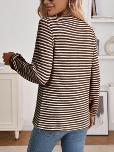 Detail of brown and white striped knit texture on a long sleeve women sweater