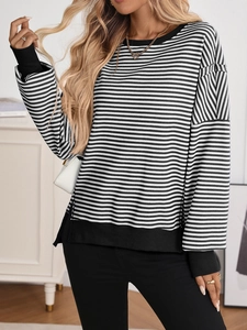 Detail of black and white striped crewneck sweatshirt with ribbed cuffs and side slits