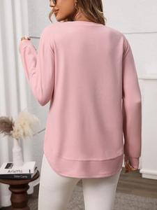 Detail view of pink waffle knit texture with ribbed cuffs and high-low curved hemline