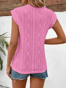 Close-up of pink knit t-shirt featuring intricate diamond hollow-out patterns and frill sleeves