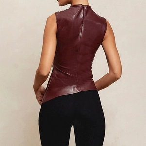 Detail of the high-collar burgundy leather vest featuring an asymmetric hem and rear zip