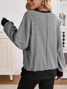 Rear view of striped oversized sweatshirt showing vertical back seam and ribbed cuffs