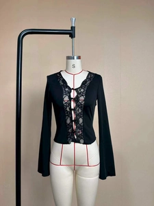 Close-up of the elegant deep V-neckline with delicate lace trim and button detail