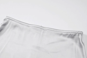 Detailed macro view of silver satin skirt waist with elastic band and premium stitching