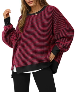 Detail of red and black striped knit sweater showing texture and ribbed cuffs