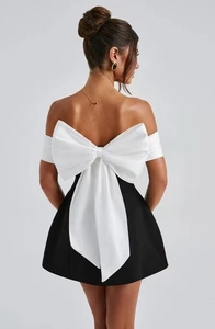 Detail of elegant black A-line mini dress with a large white satin bow on the back
