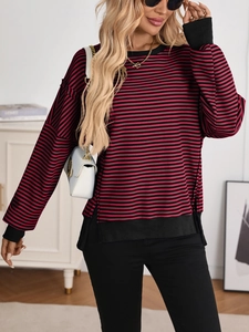 Detail of red and black striped knit sweater showing side split and ribbed patchwork hem