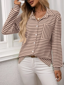 Close-up of knit striped shirt featuring a contrast pocket and white buttons details
