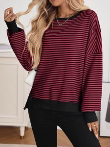 Detail of red and black striped knit sweater with ribbed cuffs and side slit features