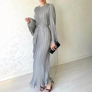 Detail of pleated grey maxi dress featuring trumpet cuffs and waist tie for a slim fit