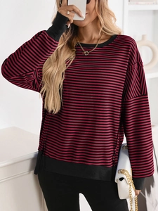 Close-up of red and black striped pullover with textured knit and black ribbed cuffs