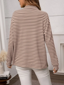 Detail view of pink and brown striped knit sweater featuring side slit hem and loose fit