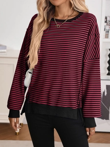 Detail view of red and black striped knit sweater with ribbed cuffs and drop shoulder