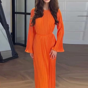 Detailed view of orange pleated fabric texture and flared cuffs on long-sleeve maxi dress