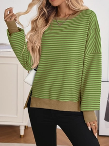 Detail of ribbed cuffs and side split hem on dark green and brown striped knit sweater