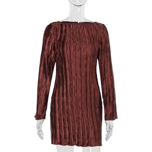 Gros plan détaillé sur la texture du tissu plissé vertical de la robe bordeaux à manches longues