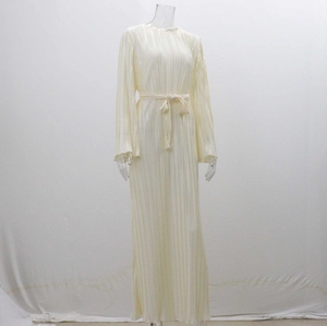 Detail of cream long-sleeve dress showing fine pleated texture and tied waist belt