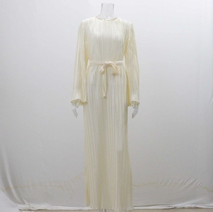 Close-up detail of pleated cream long sleeve dress with matching tie belt